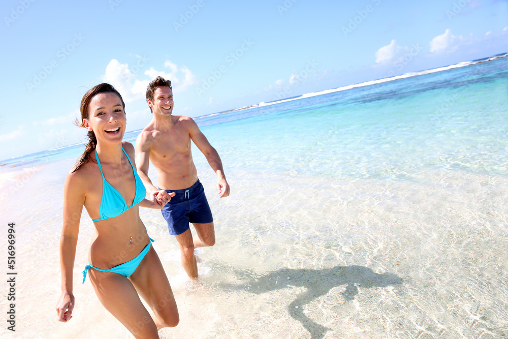 Couple running on a sandy beach