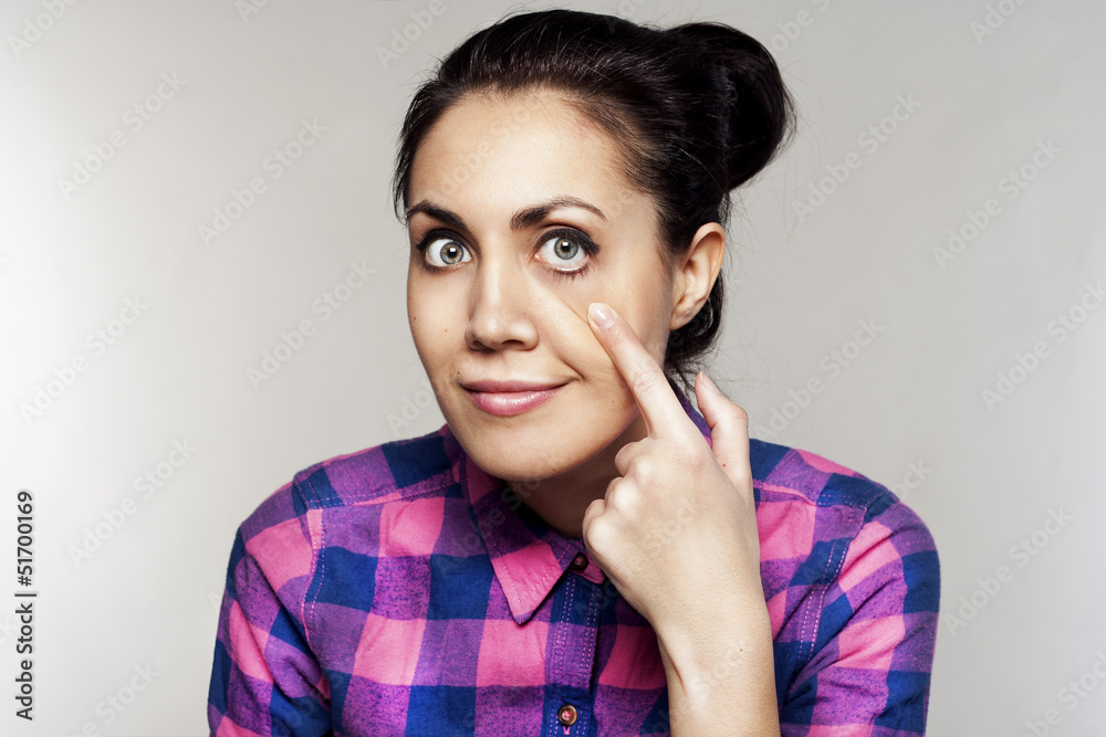 Portrait of young beautiful woman touching her eye Portrait of young beautiful woman touching her eye