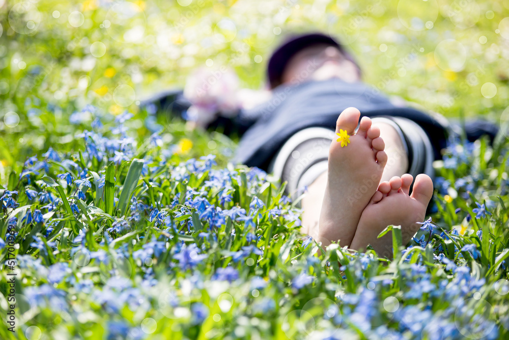 Fototapeta premium Mädchen liegt in einer blauen Blumenwiese
