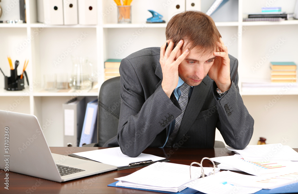 Young businessman in office at his workplace Young businessman in office at his workplace