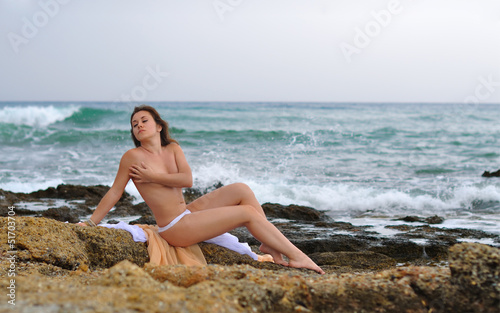 The girl topless against the storming sea