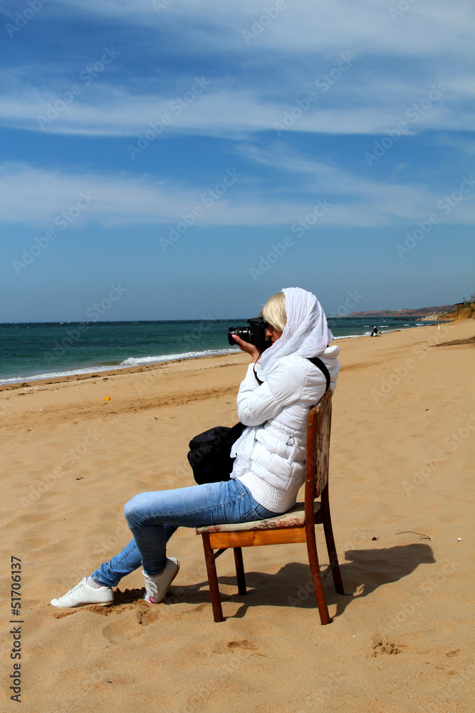 Girl photographing sea.