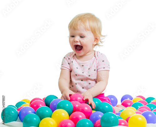 Portrait of a smiling infant playing among colorful balls