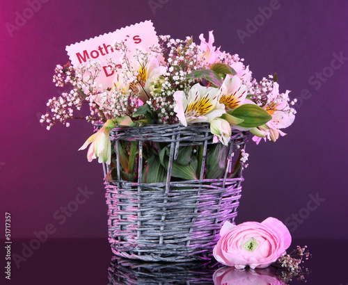 Fototapeta Naklejka Na Ścianę i Meble -  Bouquet of flowers in basket on purple background