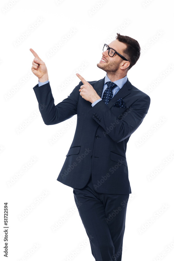Smiling young businessman pointing at copy space. Smiling young businessman pointing at copy space.