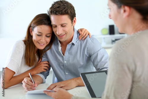 Couple signing real-estate contract photo