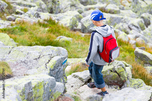 boy  crossing a rocky path