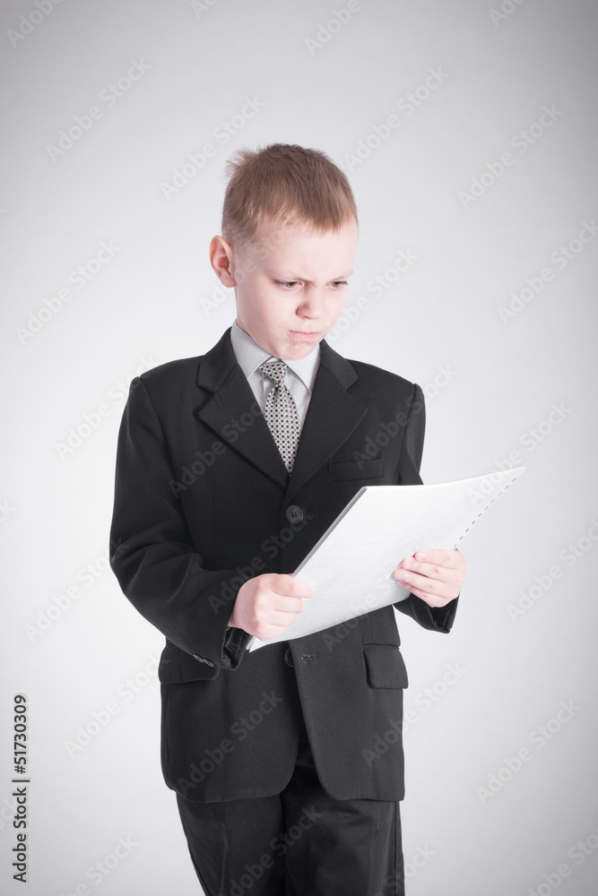 Boy looks at the stack of papers Boy looks at the stack of papers