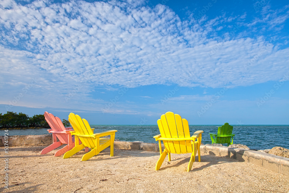 Summer scene with colorful lounge chairs on a tropical beach Summer scene with colorful lounge chairs on a tropical beach