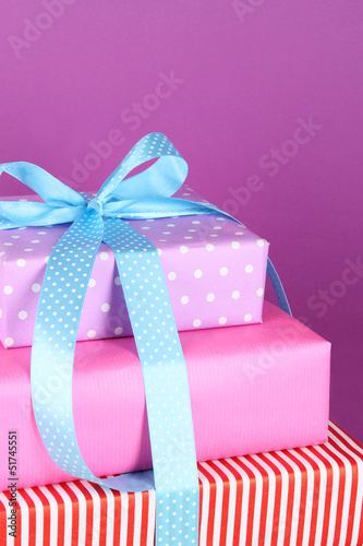 Gift box tied with a ribbon on a colored background