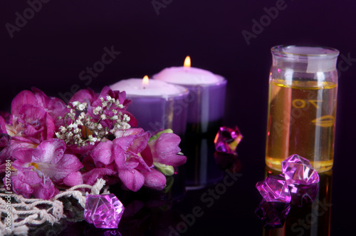 Spa oil and freesia on purple background