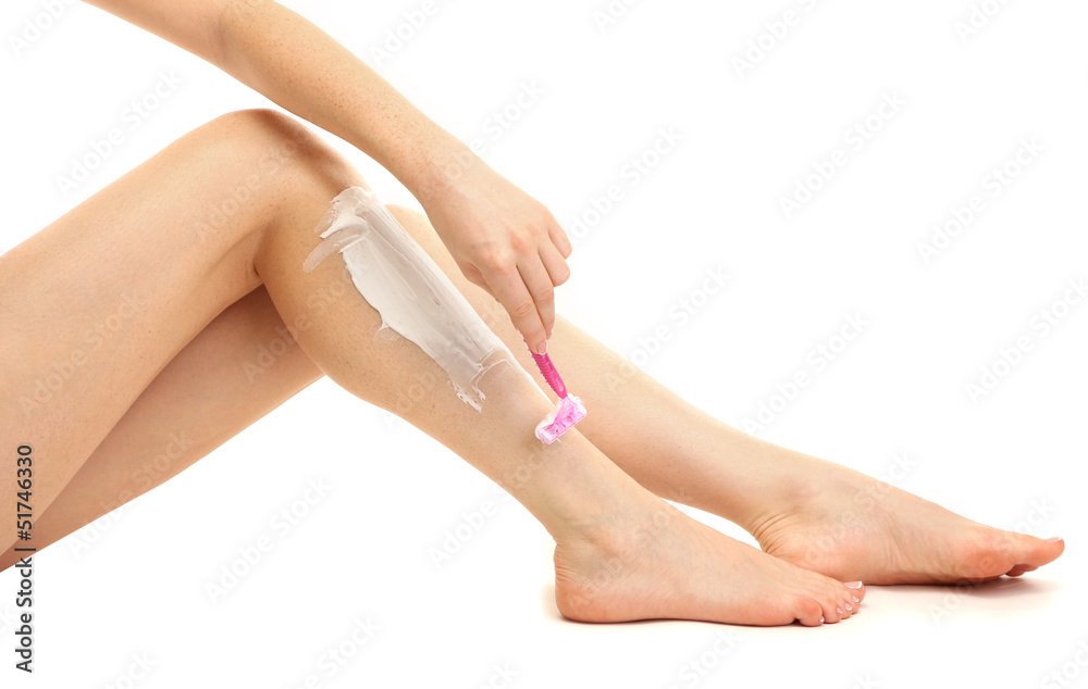 Beautiful woman is shaving her leg, isolated on white Beautiful woman is shaving her leg, isolated on white