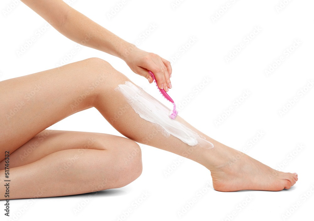 Beautiful woman is shaving her leg, isolated on white Beautiful woman is shaving her leg, isolated on white