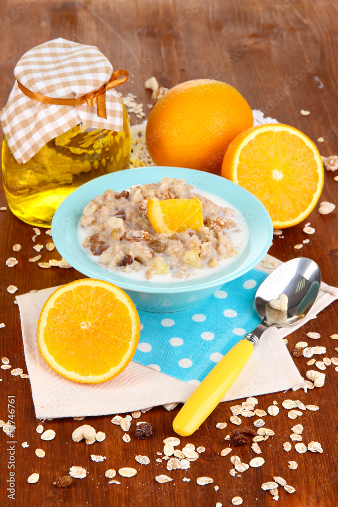 Useful oatmeal in bowl with fruit on wooden table close-up Useful oatmeal in bowl with fruit on wooden table close-up