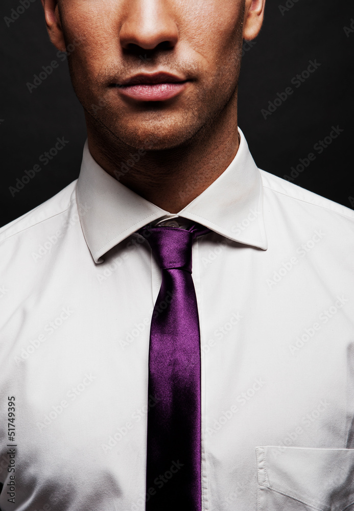 Man with purple tie over dark background Man with purple tie over dark background