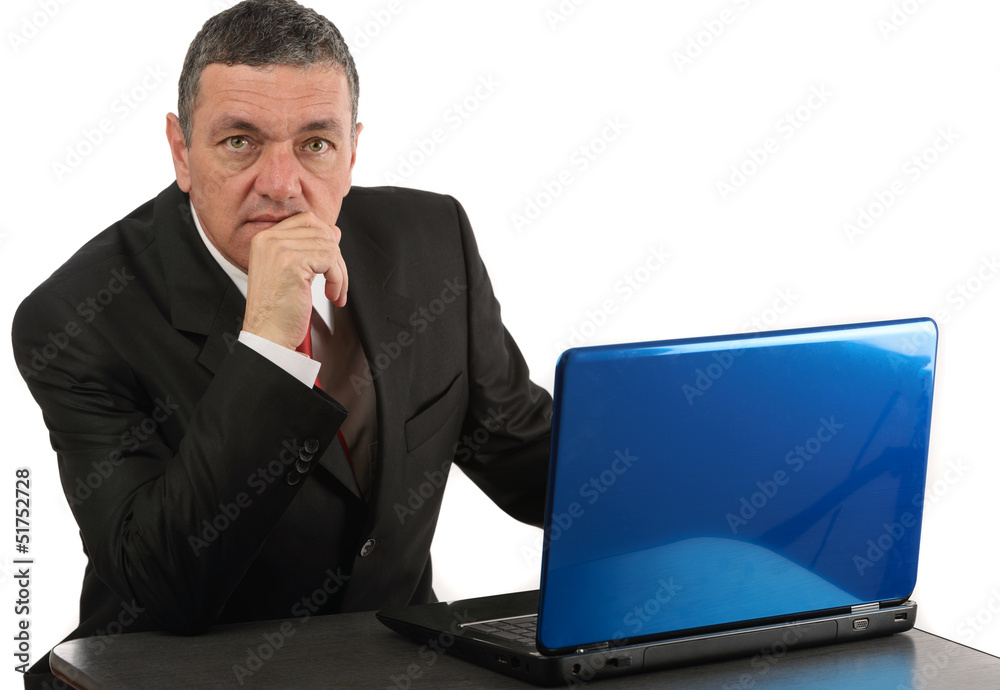 Aged businessman sitting at desk with a laptop isolated on white Aged businessman sitting at desk with a laptop isolated on white