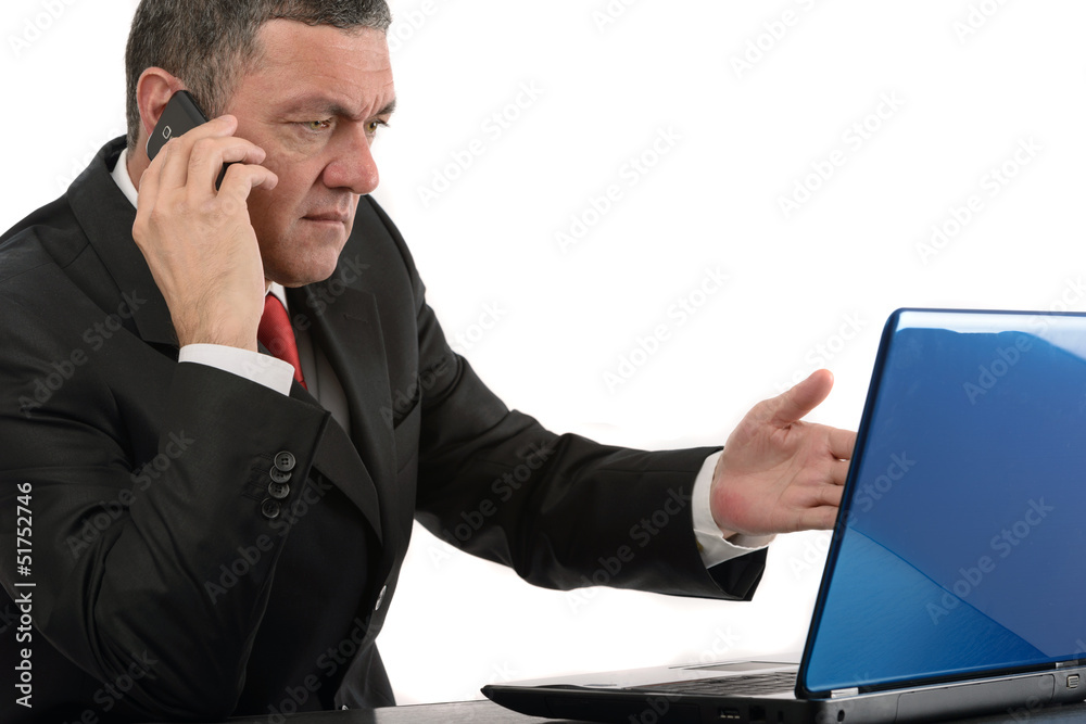 Aged businessman sitting at desk with a laptop isolated on white Aged businessman sitting at desk with a laptop isolated on white