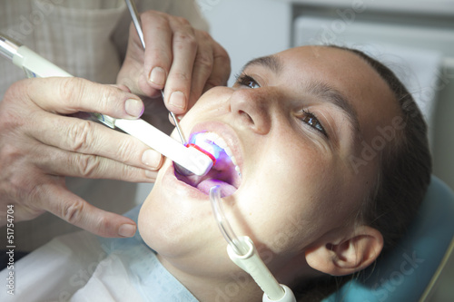 Dentist finishing dental examination with ultraviolet light