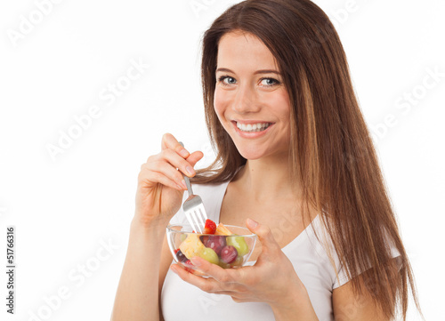 Beautiful young woman eating fruits