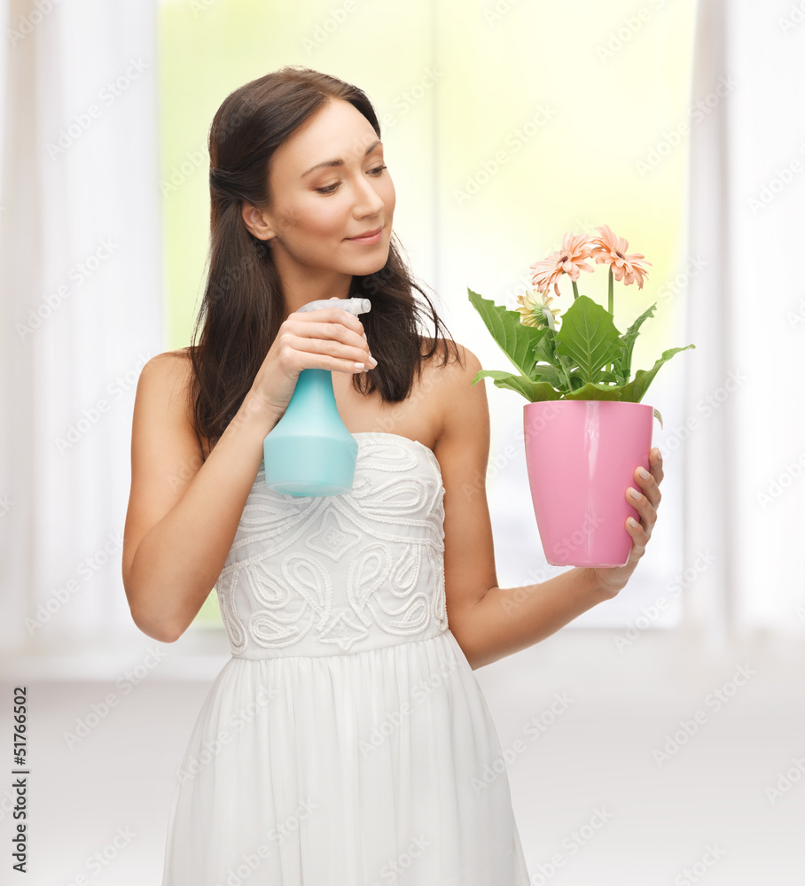 woman holding pot with flower and spray bottle woman holding pot with flower and spray bottle