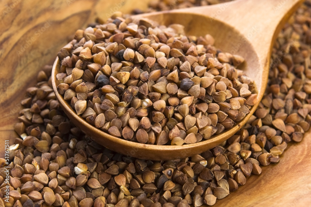 Buckwheat seeds on wooden spoon in closeup Buckwheat seeds on wooden spoon in closeup