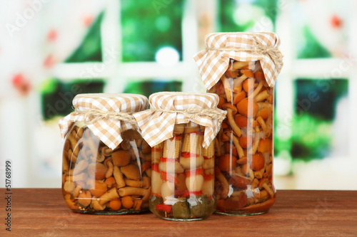 Delicious marinated mushrooms in glass jars,