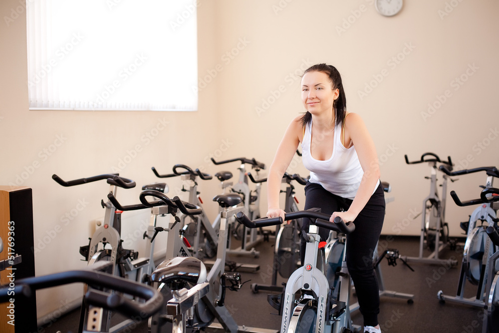 beautiful woman on an exercise bike at the gym beautiful woman on an exercise bike at the gym