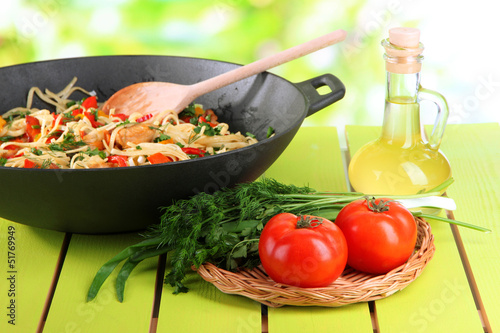 Noodles with vegetables on wok on nature background background