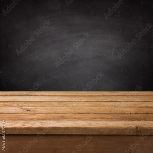 Empty wooden deck table over chalkboard