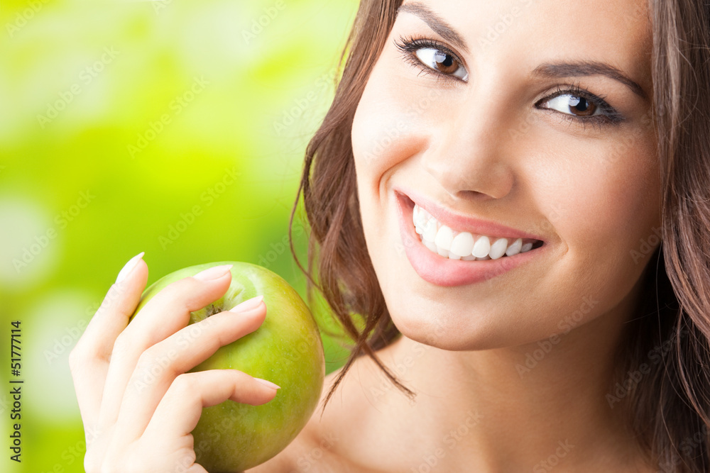 Young happy smiling woman with apple, outdoors Young happy smiling woman with apple, outdoors