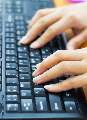 Female hands typing on a laptop