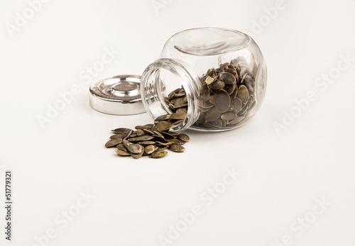 Close up of pumpkin seeds spilling out of glass jar