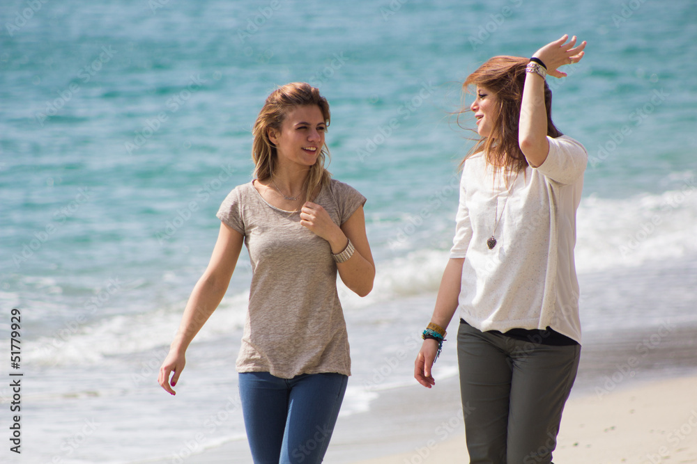 Couple of beautiful friends, walking in a seaside