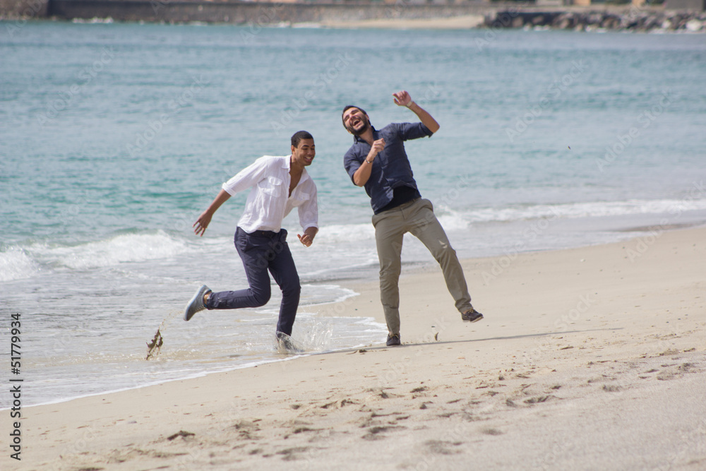 Couple of handsome friends, smiling in a seaside