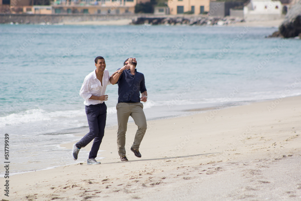 Couple of handsome friends, smiling in a seaside
