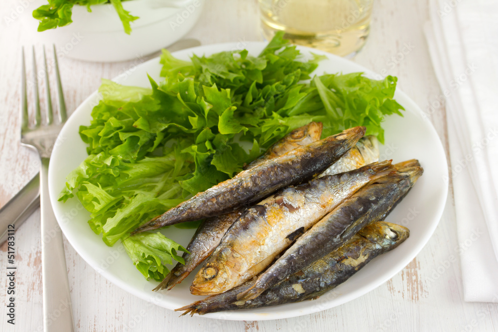 fried sardine with lettuce on the plate fried sardine with lettuce on the plate