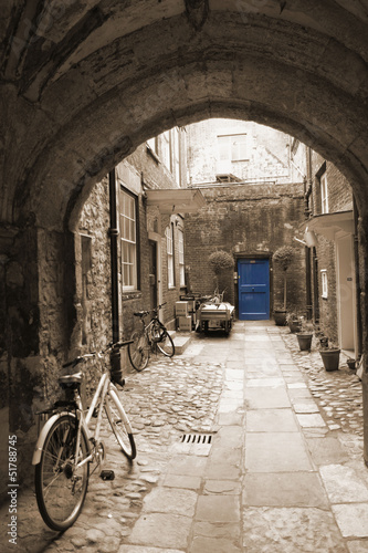 Back alley in London, with bikes, blue door at the end #51788745