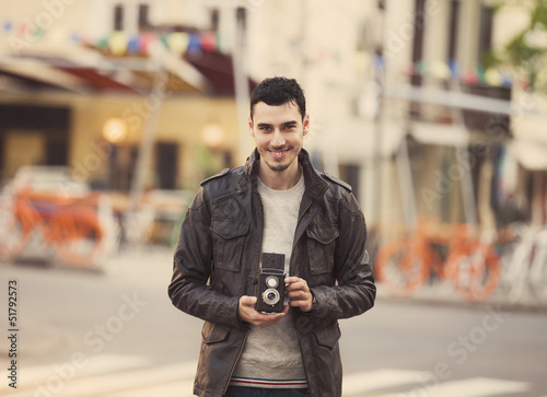 Teen guy with retro camera at outdoor