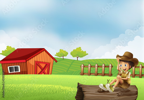 A boy at the farm sitting in the wood with a wooden house photo