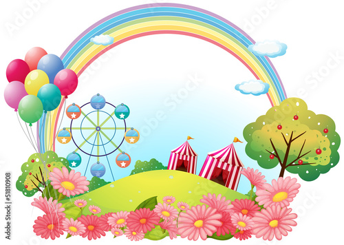 A hill with circus tents, balloons and a ferris wheel