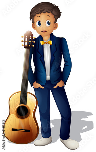 A boy standing beside the guitar