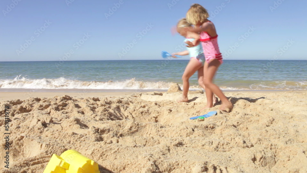Two Young Girls Playing On Beach Together