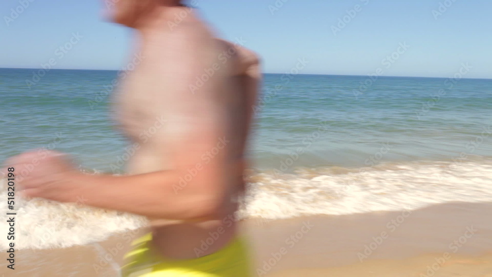Multi Generation Family Running Along Beach Multi Generation Family Running Along Beach