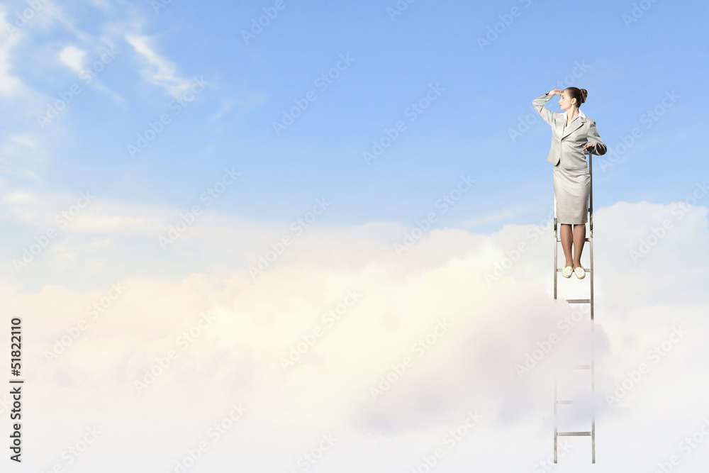 Businesswoman standing on ladder