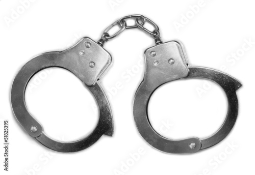 Old steel handcuffs on a white background.