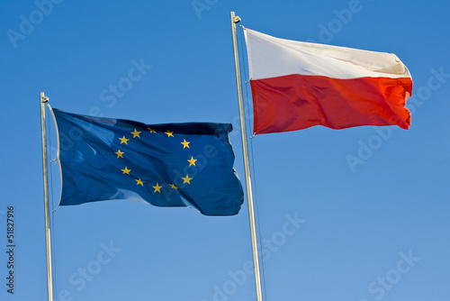 European union flag and a Polish flag on a background of sky