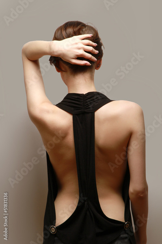 A beautiful woman, back view, isolated on brown background