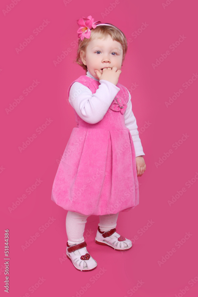 Full length portrait of funny little girl standing over pink bac Full length portrait of funny little girl standing over pink bac