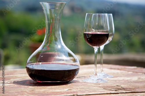 Red wine in a wine carafe and a two wine glasses in vineyard photo