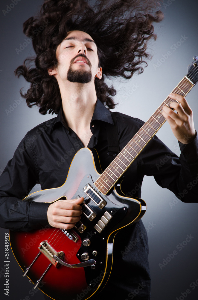 Obraz premium Man playing guitar during concert